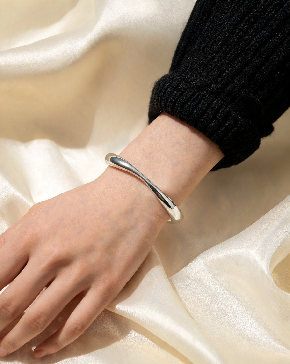 The Twist Cuff in silver, worn on the wrist
