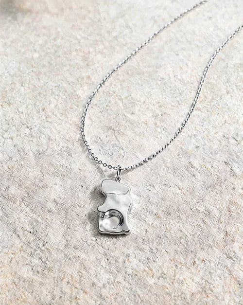 The Molten Pendant in silver, a hammered molten-look pendant on a fine steel chain